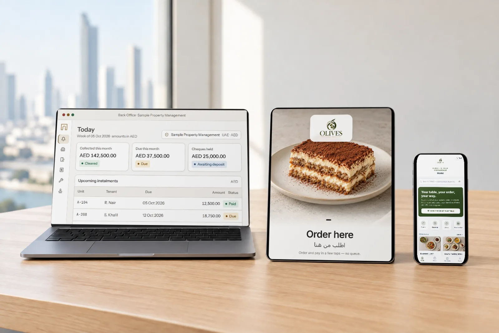 A laptop, tablet and phone on a desk showing a property back office, a restaurant ordering screen and a customer app